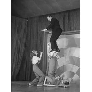  Milton Berle Teetering on Acrobats Feet, During His 