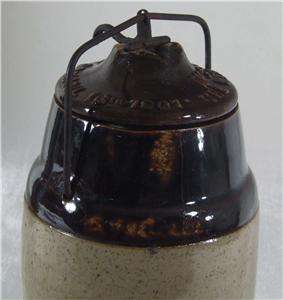This nice old Weir stoneware storage jar has its original locking wire 