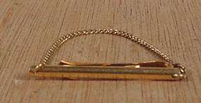 We are offering a designer bar tie clasp with chain made by Krementz 