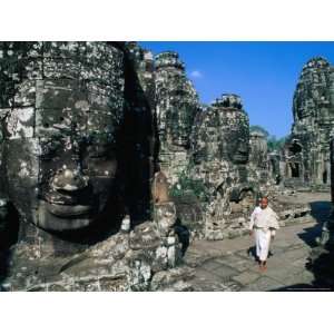  Buddhist Nun Walking Amongst Massive Stone Faces in Temple 